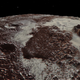 A dramatic view showing the rugged high rim of the Sputnik Planitia basin and the nitrogen-methane ice sheet that partially fills its floor.